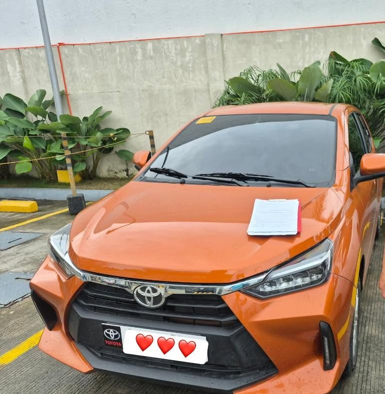 Orange Toyota Wigo 2025 automatic with the rental papers on the bonnet
